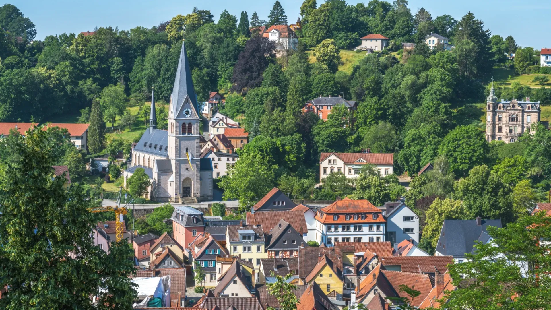 Kirche und Wohnhäuser am begrünten Hang in Kulmbach